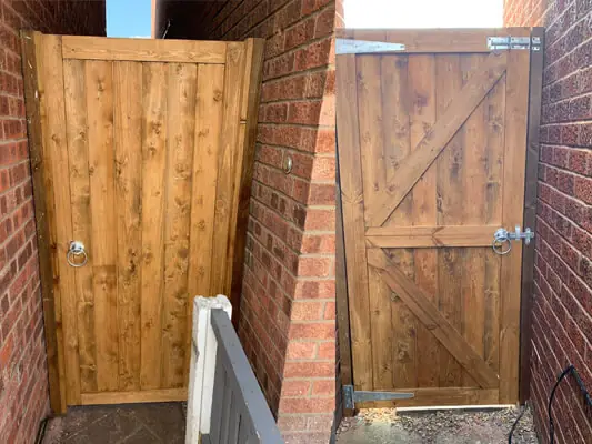 Wooden garden gates fitted between brick walls