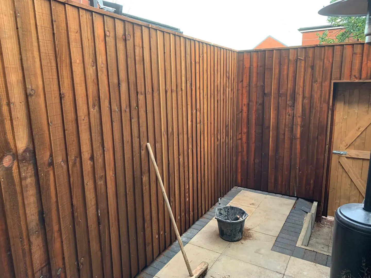 Boarded timber fencing beside a paved area