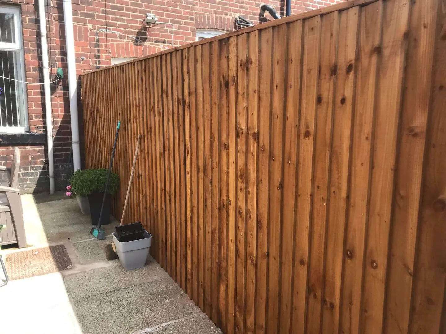 Closeboard timber fencing fitted beside a paved garden area